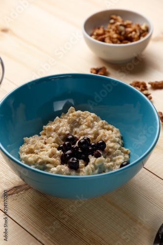 Wallpaper Mural Porridge in a bowl with the berries, walnuts on bright wooden table. Healthy breakfast image. Copy space Torontodigital.ca