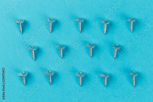 Tapping screws made of steel on blue background. Concept. Top view. Flat lay