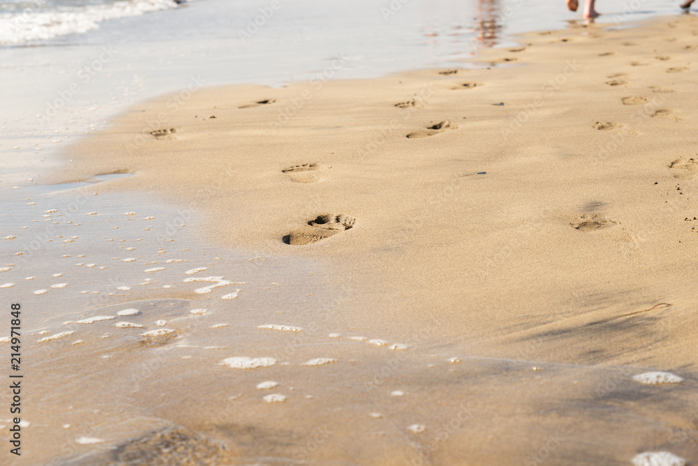 Maspalomas, Canarias islands/ Spain-July 22, 2018: Couple of man and woman walking on Canarias sand from Sahara desert, view of wet foot traces. Blue Atlantic ocean and beach on Gran Canaria. Maspalomas, Canarias islands/ Spain-July 22, 2018: Couple of man and woman walking on Canarias sand from Sahara desert, view of wet foot traces. Blue Atlantic ocean and beach on Gran Canaria.