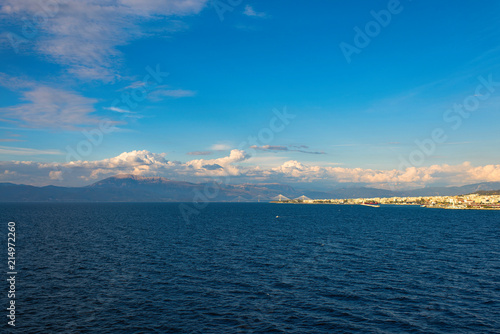 View from the ferry ship on the Rion-Antirion bridge and port of Patra city at sunset in the Ionian Sea, Greece © flowertiare