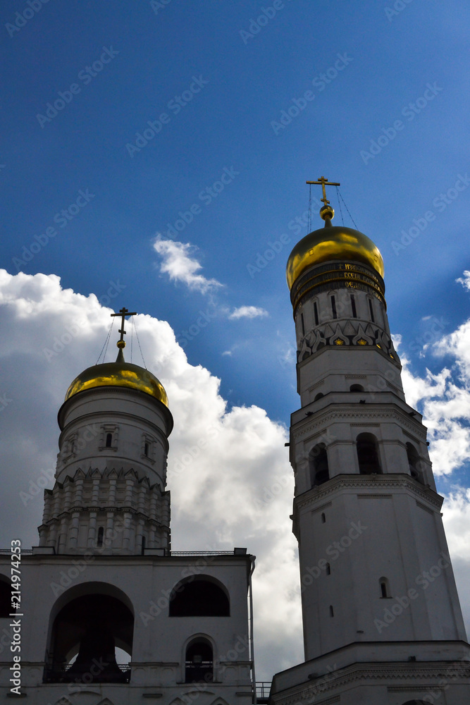 Fototapeta premium Two towers of the bell tower of Ivan the Great opposite the blue sky. Bottom view