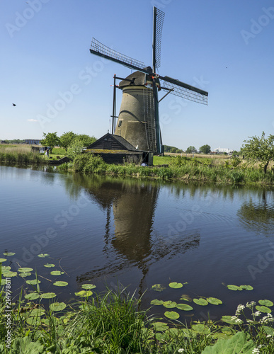Kinderdijk Windmill Reflection. Picturesque landscape of the historic Kinderdijk windmills, a UNESCO World Heritage Site. Here one of the mills is reflected in the nearby river. 