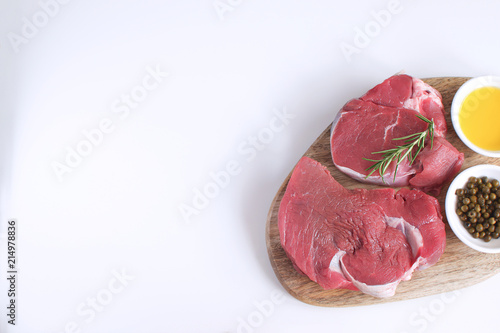 Fresh raw meat beef steak olive oil Spices Pepper Rosemary Cooking concept White background Top view Copy space Flat lay