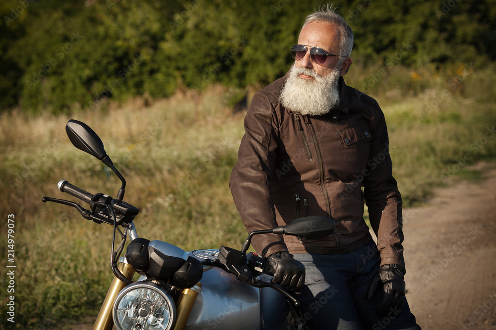 Old rider biker man in black leather jacket, jeans, boots and helmet sit on  classic style cafe racer motorcycle. Brutal fun urban lifestyle. Outdoor  portrait. Stock Photo | Adobe Stock