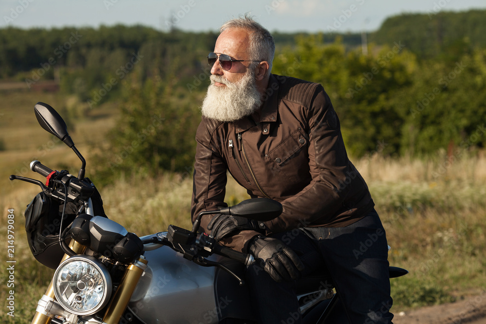 Old rider biker man in black leather jacket, jeans, boots and helmet sit on  classic style cafe racer motorcycle. Brutal fun urban lifestyle. Outdoor  portrait. Stock Photo | Adobe Stock