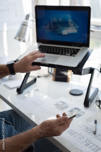 Man preparing architectural design on laptop at home photo