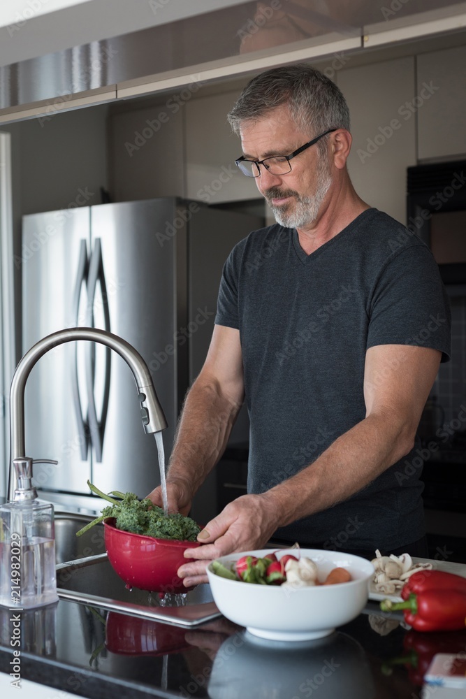 Man washing vegetables in kitchen Man washing vegetables in kitchen