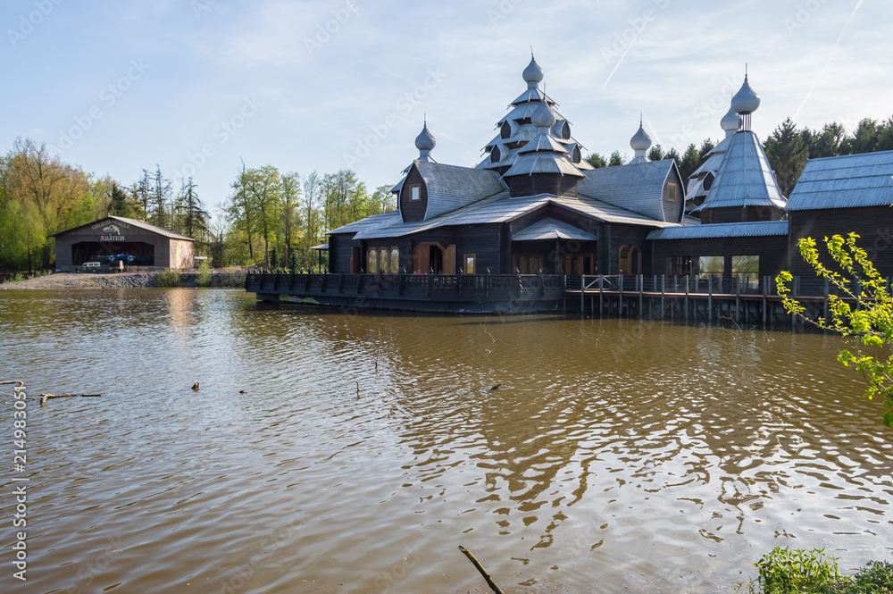 Russian architecture building on a lake with an aviation hangar in the background