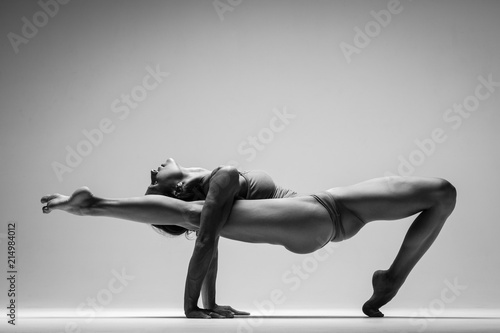 Young beautiful yoga woman is posing in studio. Black and white