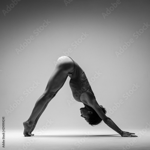 Young beautiful yoga woman is posing in studio. Black and white