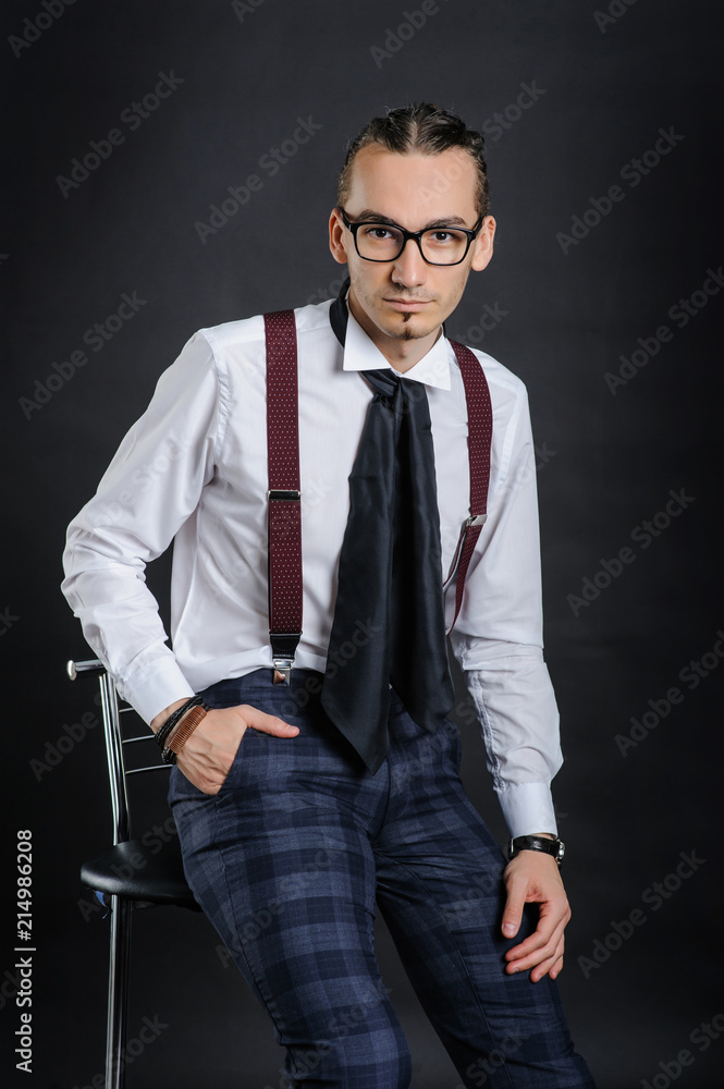 Fototapeta premium Young handsome boy in white shirt with tie sitting on the chair