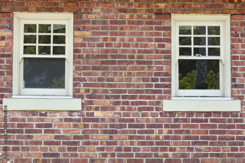 Vintage variegated brick wall and two windows