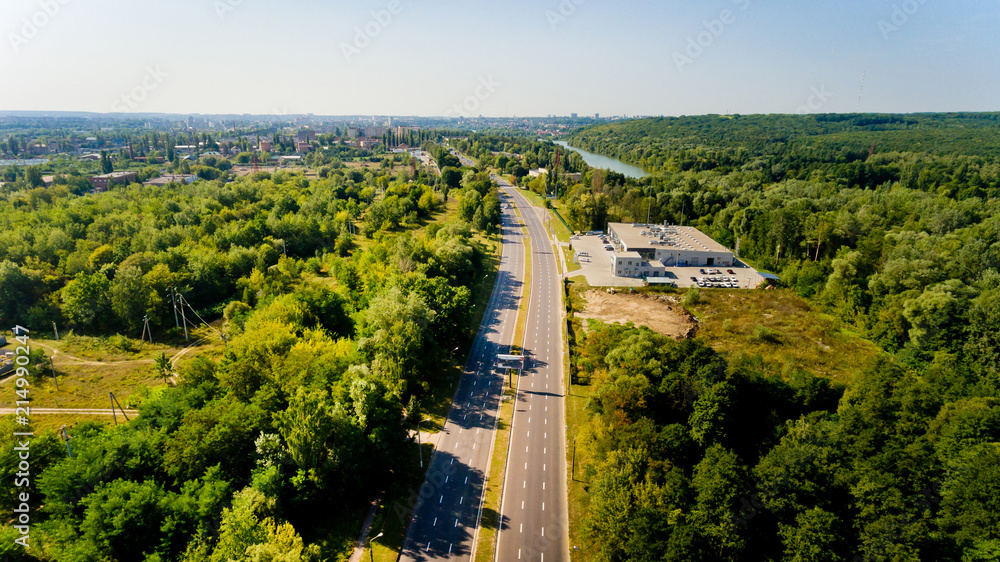 Aerial view of asphalt road passes through forest.