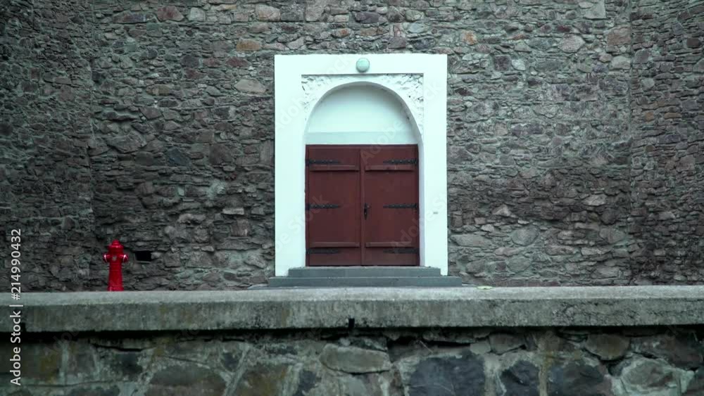 Wooden door of an old stone building. brown wooden, double door with white stone wall edging. Wooden door of an old stone building. brown wooden, double door with white stone wall edging.