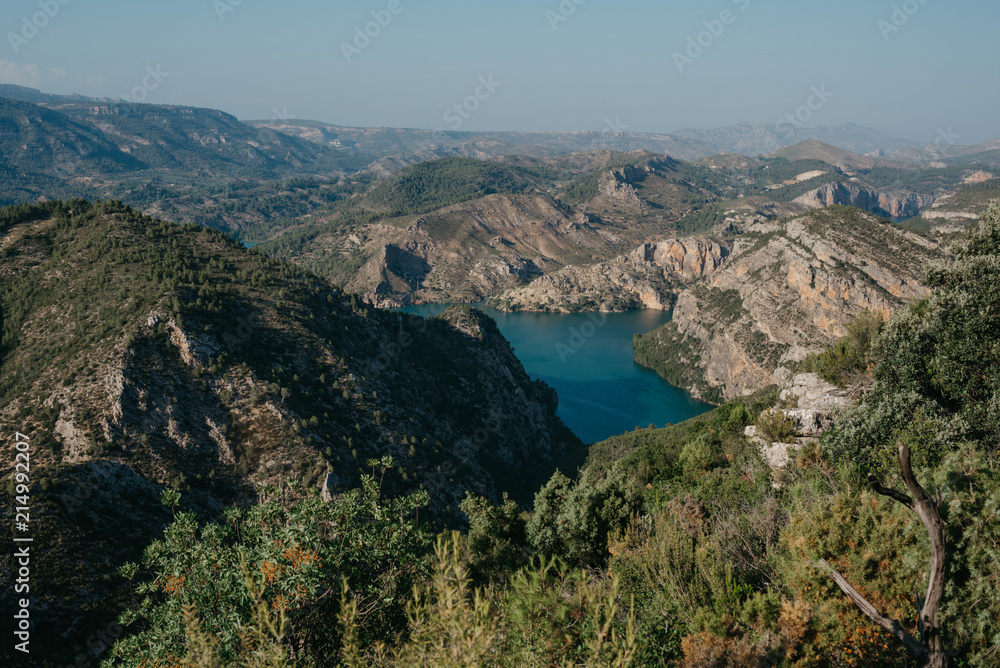Beautiful emerald lake in the center of valley covered with forest in the evening in Spain