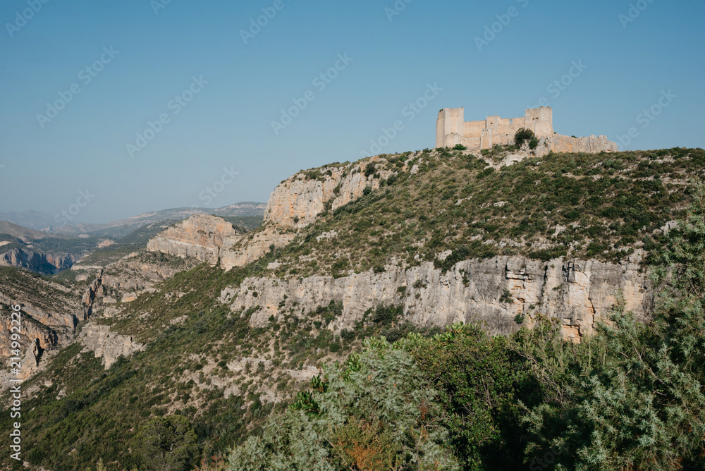  An ancient castle on the top of the hill above the valley in Spain on the sunset. El Castillo de Chirel. 
