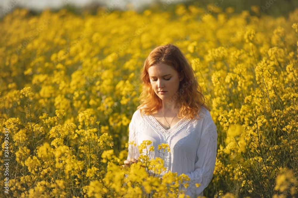 Woman touching crops in the mustard field Woman touching crops in the mustard field