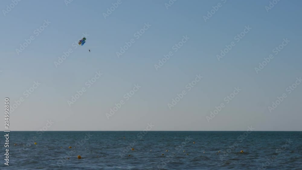 Tourist parasailing with parachute over the sea with blue sky Tourist parasailing with parachute over the sea with blue sky