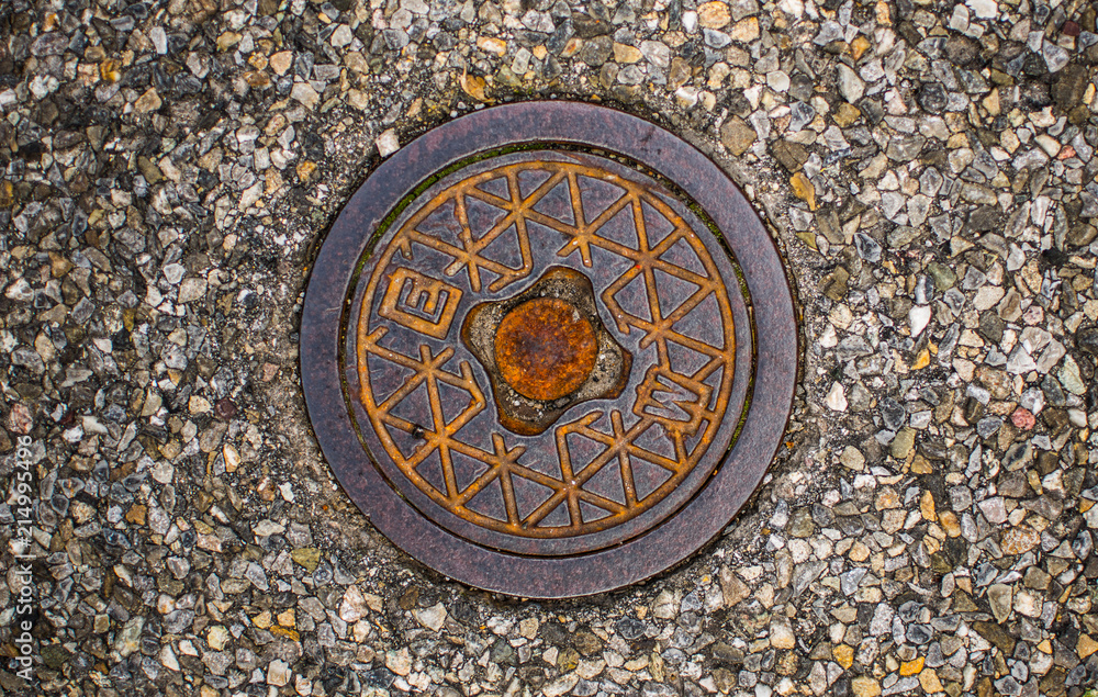 Old rusty sewer cover on street out of heavy metal