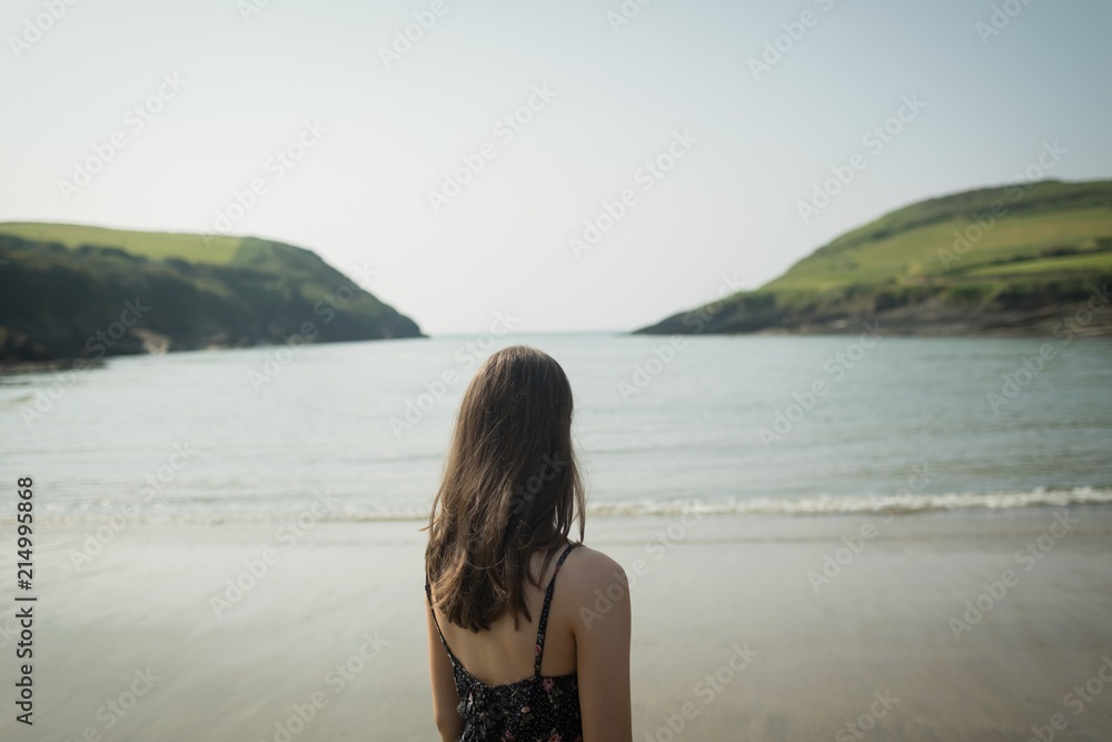 Rear view of woman standing on beach Rear view of woman standing on beach