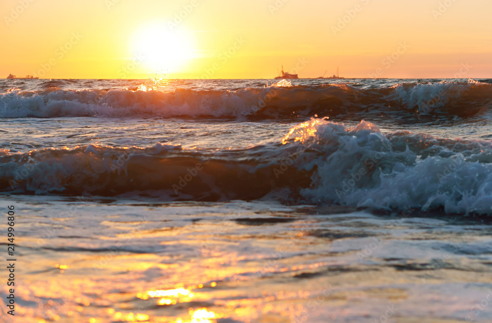 Obraz premium Sunset over the sea. Reflection of sunlight in the sea waves. Red sky in the rays of the sunset.