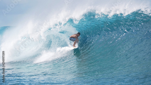Photography Wild ocean wave curls over the pro surfboarder enjoying the summer holiday