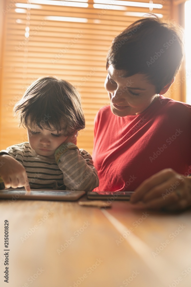 Mother teaching to son on digital tablet Mother teaching to son on digital tablet