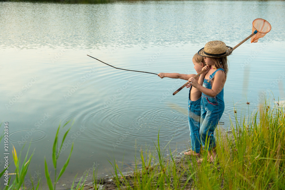 Two children with a butterfly net near the river Two children with a butterfly net near the river