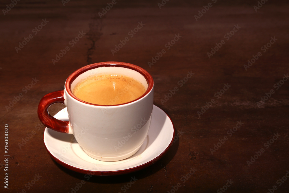 A cup of espresso coffee on a dark wooden background A cup of espresso coffee on a dark wooden background