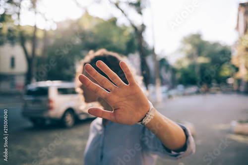 Beautiful young woman covering face with her palm photo