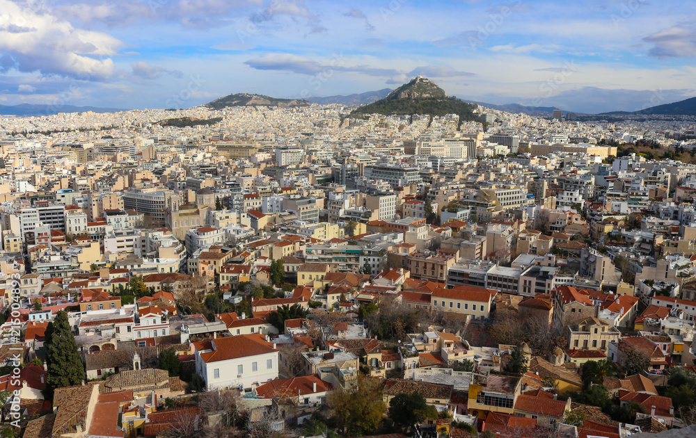 View of the rooftops of Athens with their interesting patios and roof gardens looking north over Thiseio toward Mount Lycabettus perched high on a hill and crowned with the Chapel of St George and a t