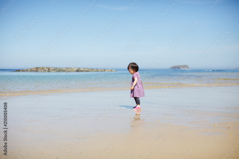baby girl wearing sunglasses running on the summer beach baby girl wearing sunglasses running on the summer beach