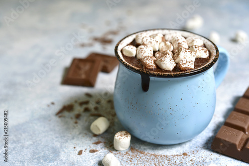 Homemade hot chocolate with mini marshmallow in a blue enamel mug.Rustic style.