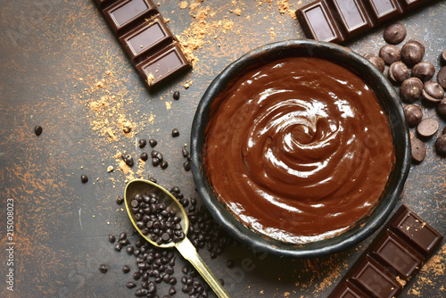 Chocolate ganache in a black bowl with ingredients for making.Top view. photo