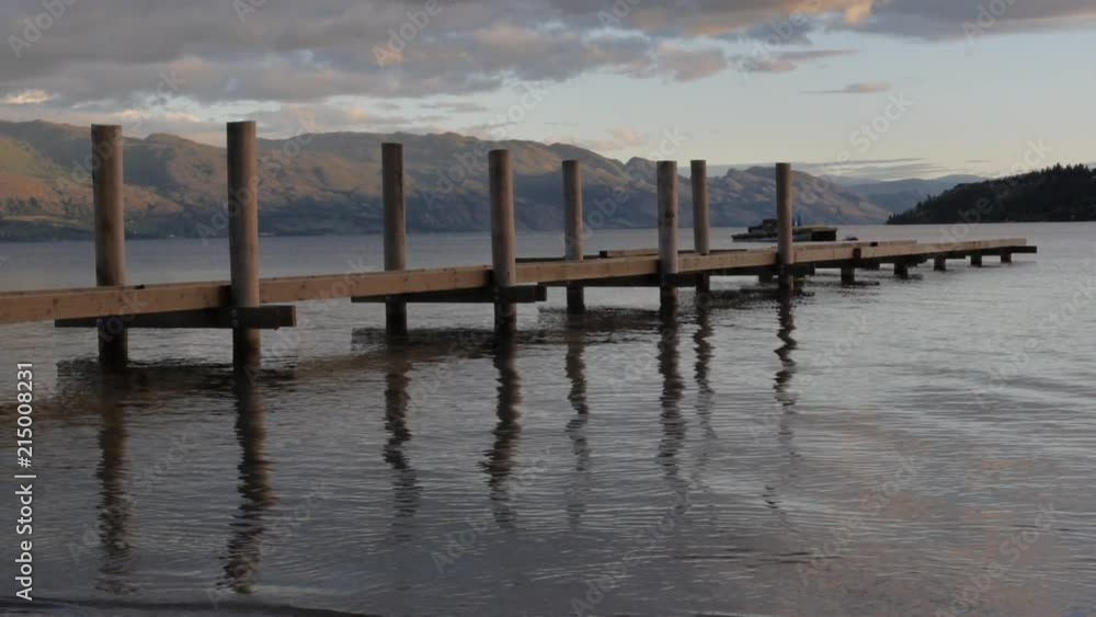 Slow Motion Calm Water Waves Rippling Beside Wooden Dock in Lake at Sunset Slow Motion Calm Water Waves Rippling Beside Wooden Dock in Lake at Sunset