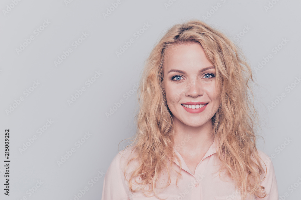 Fototapeta premium Portrait of young attractive nice cute caucasian smiling curly-haired blonde girl wearing casual shirt. Isolated over grey background