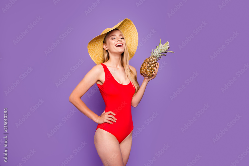 Φωτογραφία Young attractive nice gorgeous blonde smiling girl with straight hair wearing full red swimsuit and wide-brimmed sunhat, relaxed, holding pine apple