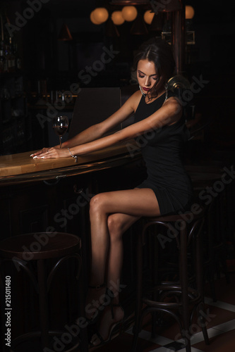 elegant lady in black dress, in restaurant at a bar