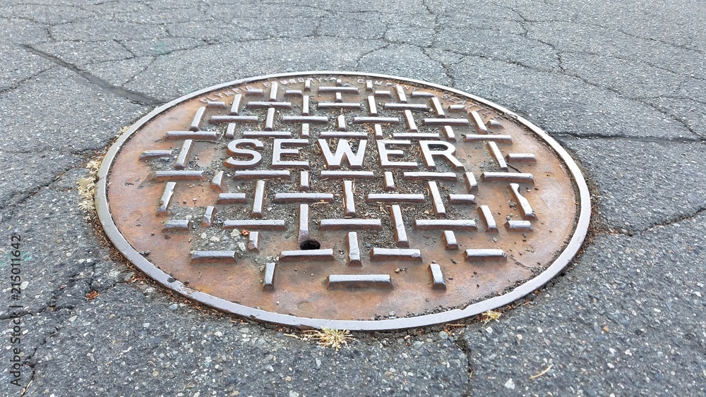 Sewer metal cap on the road in close up