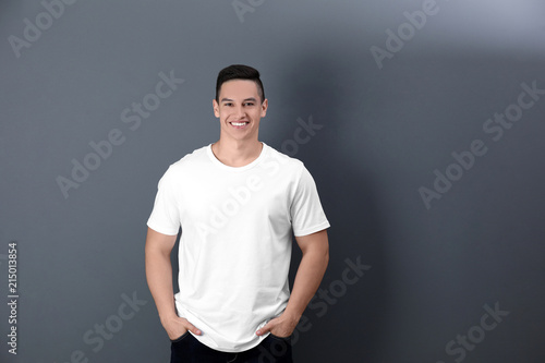 Young man in white t-shirt on color background. Mockup for design