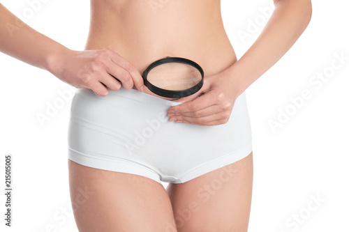Young woman with magnifying glass near underwear on white background. Gynecology