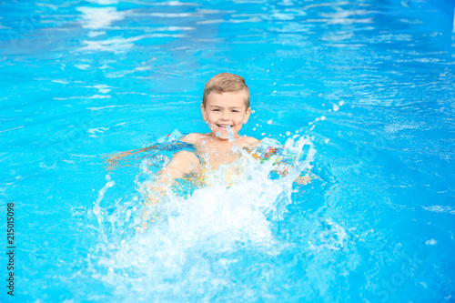 Little boy in swimming pool on sunny day
