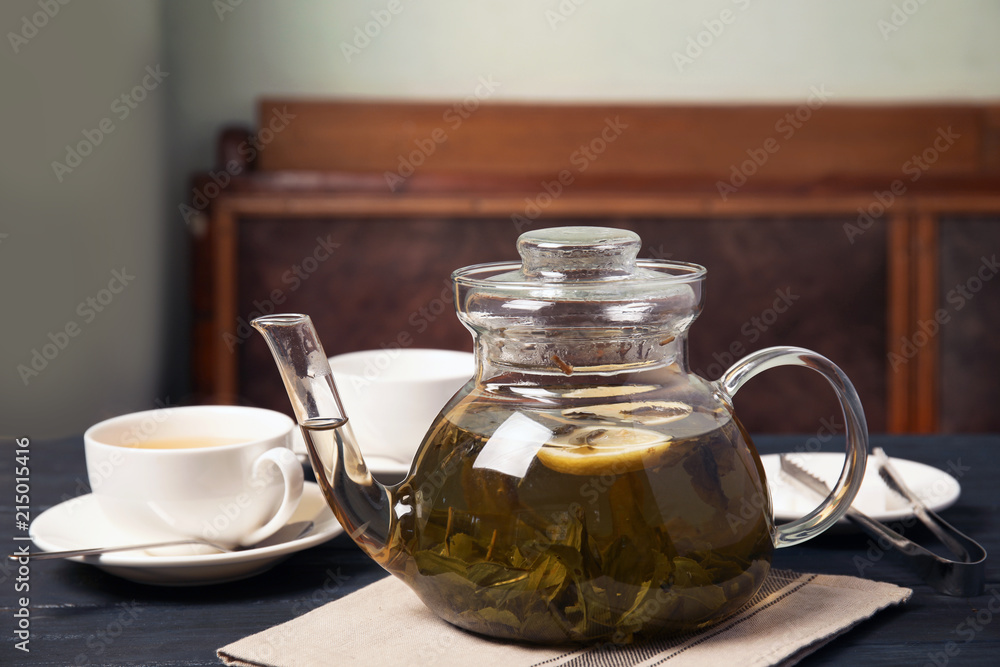 Teapot with hot aromatic tea on table Teapot with hot aromatic tea on table