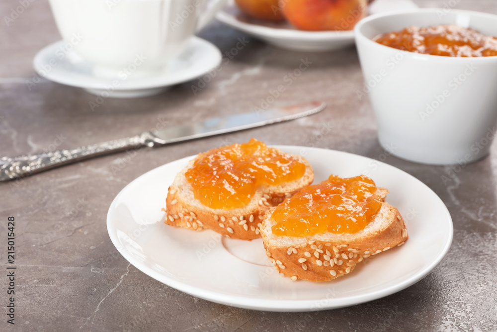 Plate with bread and tasty peach jam on table Plate with bread and tasty peach jam on table