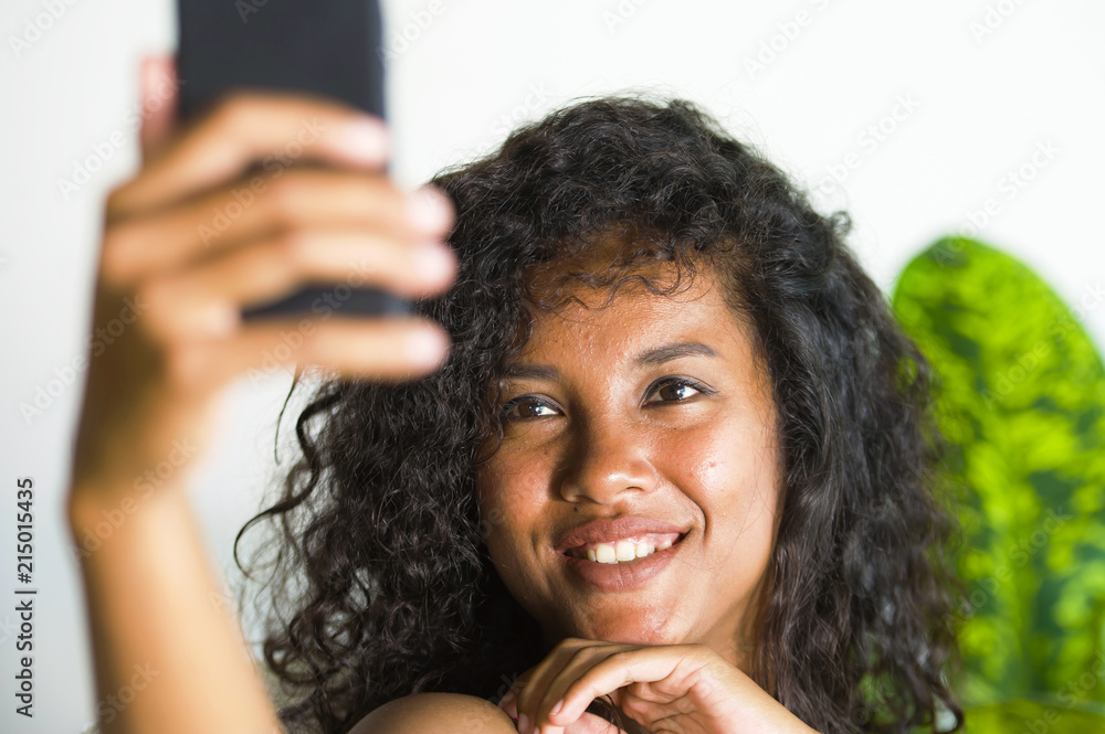 young attractive and beautiful happy black afro American woman taking selfie portrait picture with mobile phone at holidays apartment young attractive and beautiful happy black afro American woman taking selfie portrait picture with mobile phone at holidays apartment