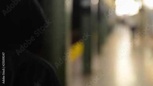 ragazzo cammina in metropolitana con il cappuccio di una tuta photo