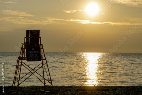 Lifeguard chair on beach at sunset in New York