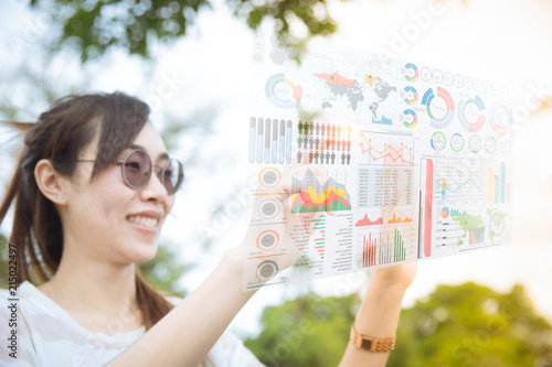 Asian chinese girl using advance technology of computer hologram air screen display mix media business information data chart outdoor
