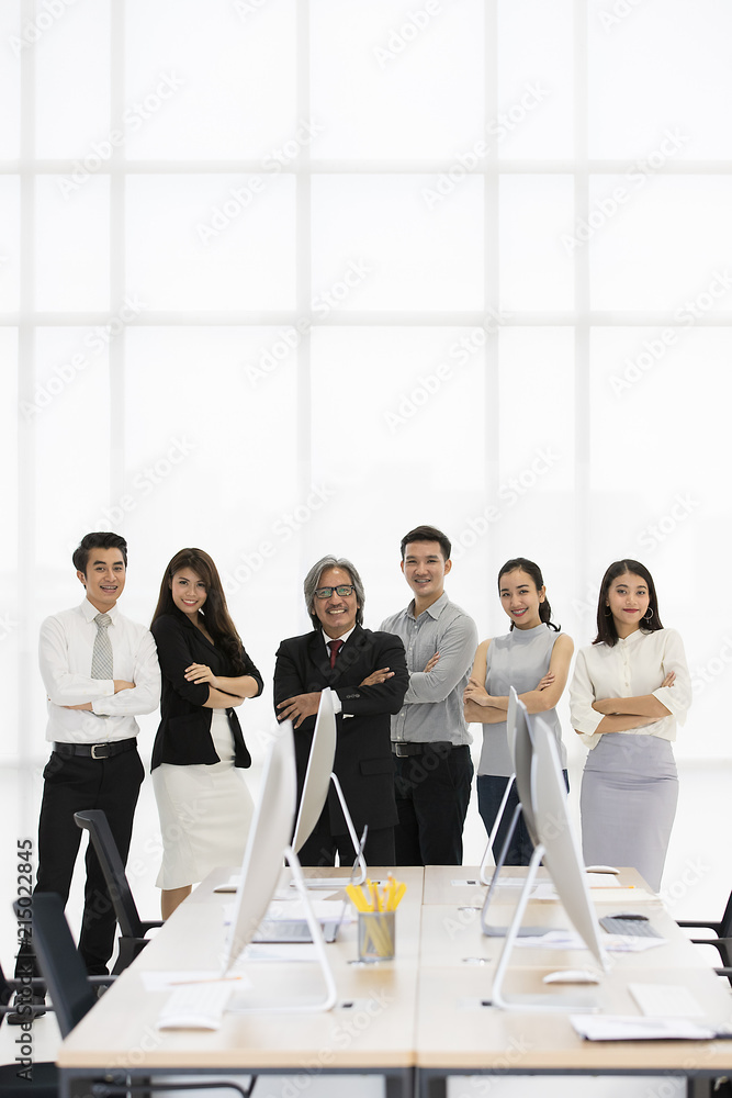 Group of 6 Asaina business people standing together in modern office, smiling and lookig fo camera.