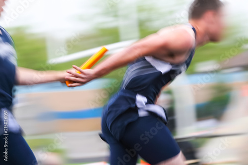 Motion blurred relay race at a track and field event photo